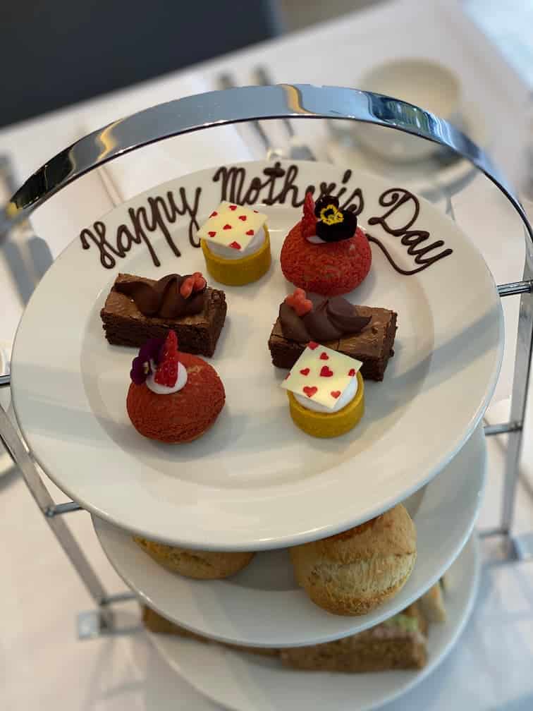 Little Pastries Served on a plate with "Happy Mothers Day" written with melted chocolate