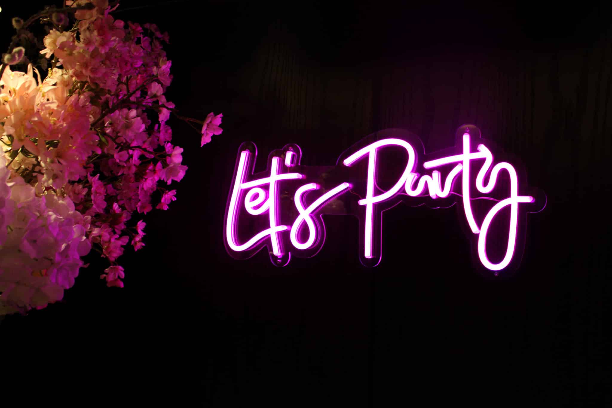 Neon lights spelling "Let's party"