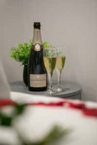 A bottle of louis roederer and two full champagne glasses