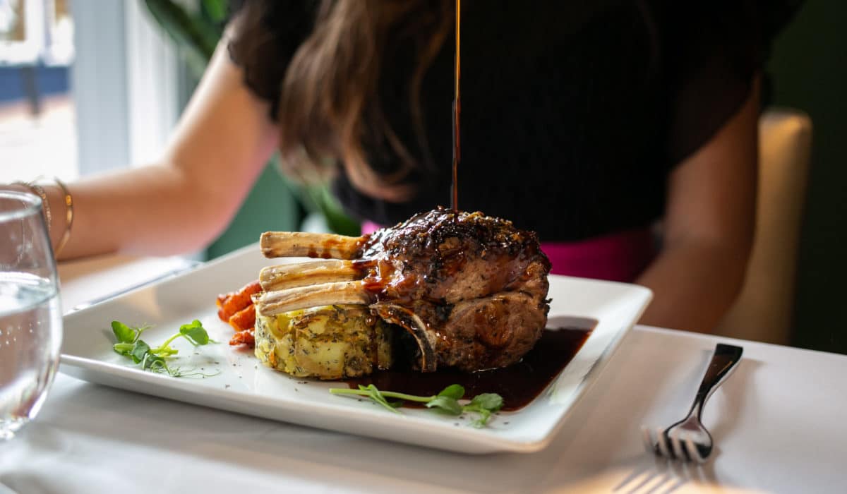 Meat dish served with vegetables with gravy being poured on it