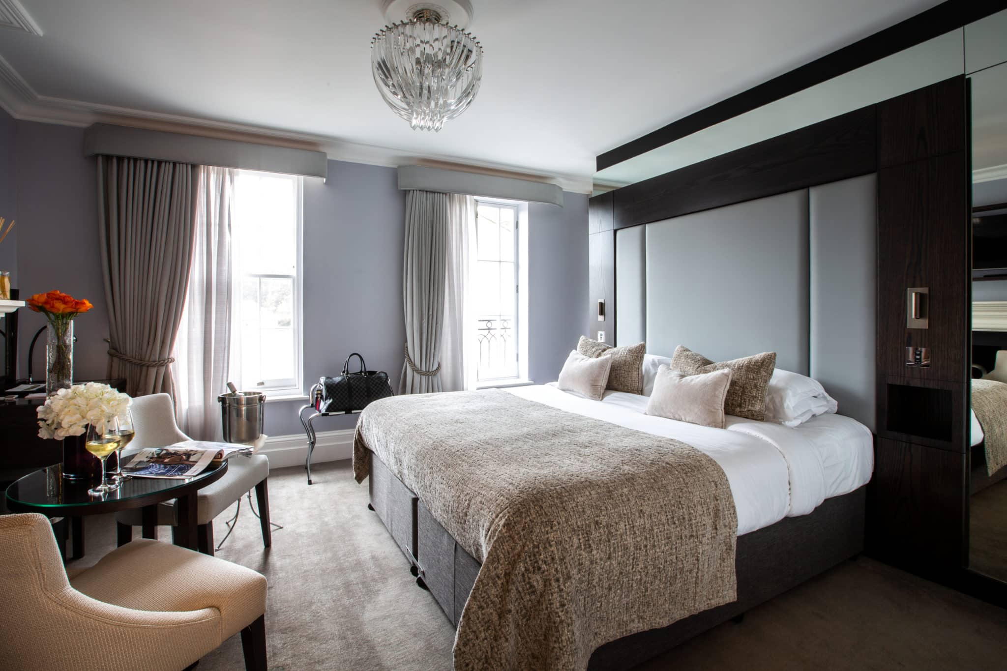 Deluxe Room with a double bed and a seating area with wine