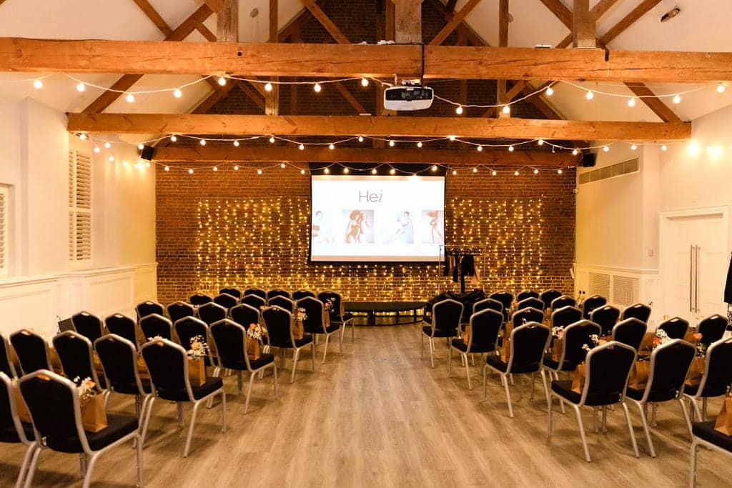 Venue hire at One Warwick Park Hotel in Kent featuring exposed brick walls, wooden beams and guest chairs ready for a business event.