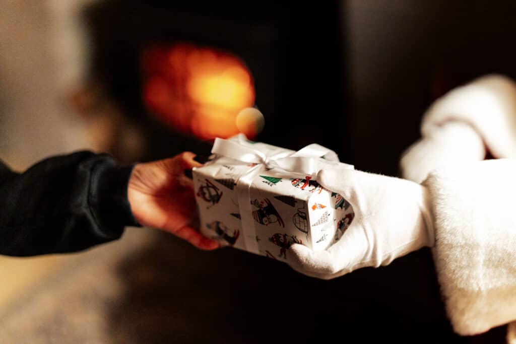 Santa handing his Elf a gift at One Warwick Park Hotel's Christmas experience