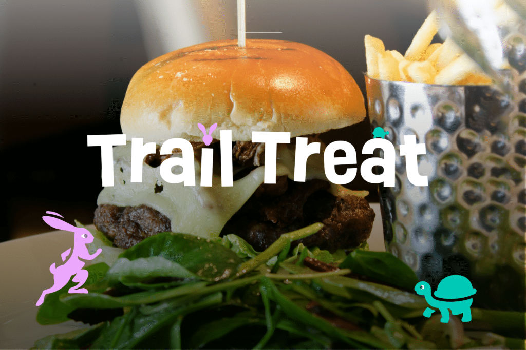 Burger and fries with salad served at The Brasserie in Tunbridge Wells, promoting the Trail with a Tale summer offer: free kids’ meals with every adult main. Text reads ‘Trail Treat’.