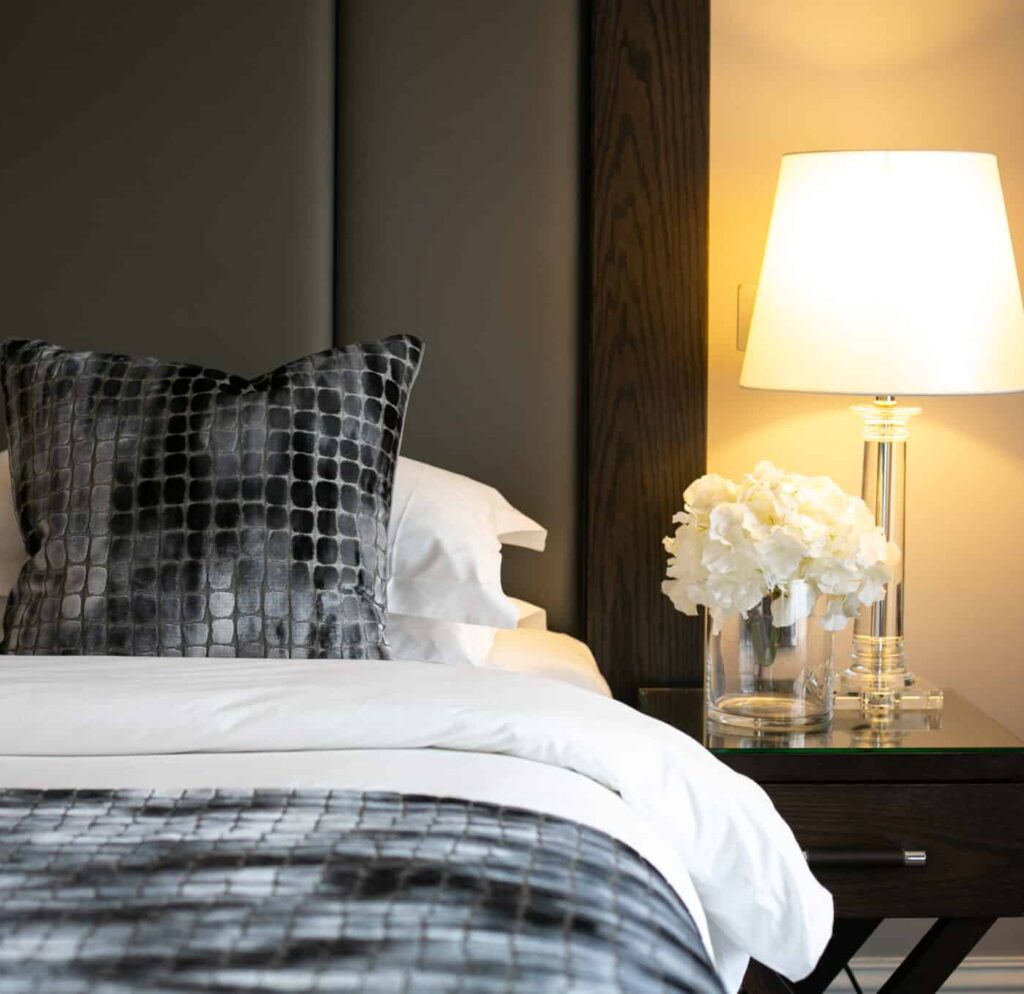 Luxury Tunbridge Wells hotel bed featuring bedside table with glowing lamp shade
