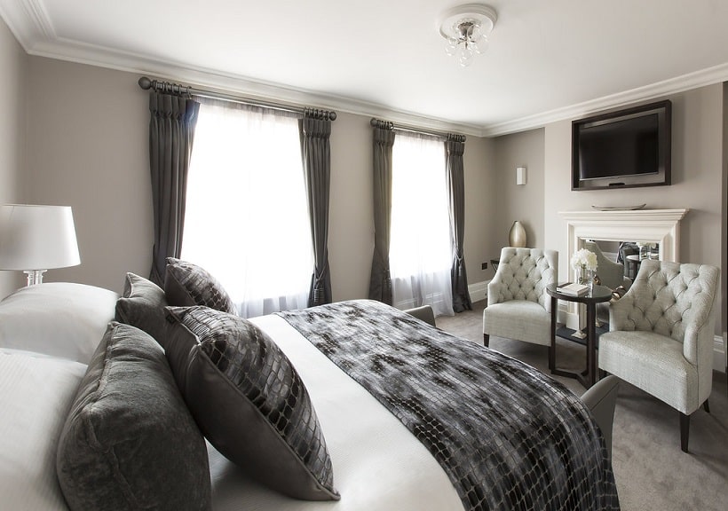 A bright, elegant hotel room with a king-sized bed, plush seating and natural light, showcasing premium accommodation available during Black Friday hotel offers in Tunbridge Wells.