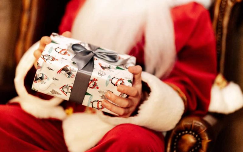 Christmas Days out in Tunbridge Wells at One Warwick Park Hotel's Santa's Brunch Club featuring Santa holding a beautifully wrapped Christmas gift