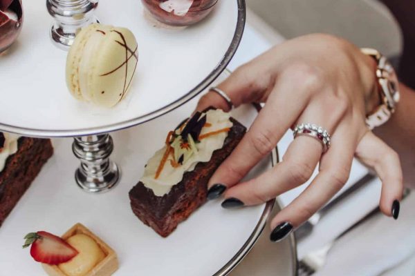 Person picking a pastry from a plate